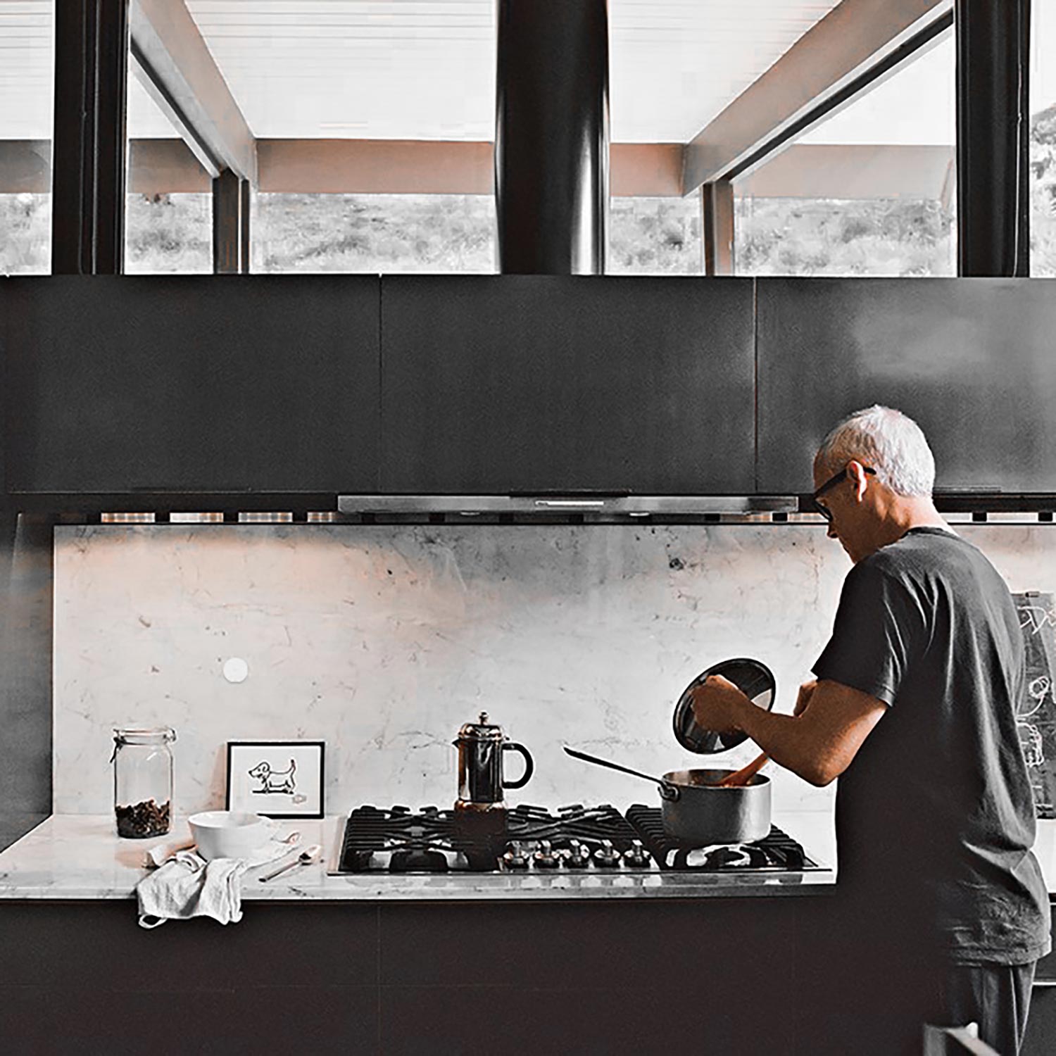 A modern kitchen with wooden cabinets, open shelves displaying dishes, and a sleek sink area with Josh AI nano white on the wall.