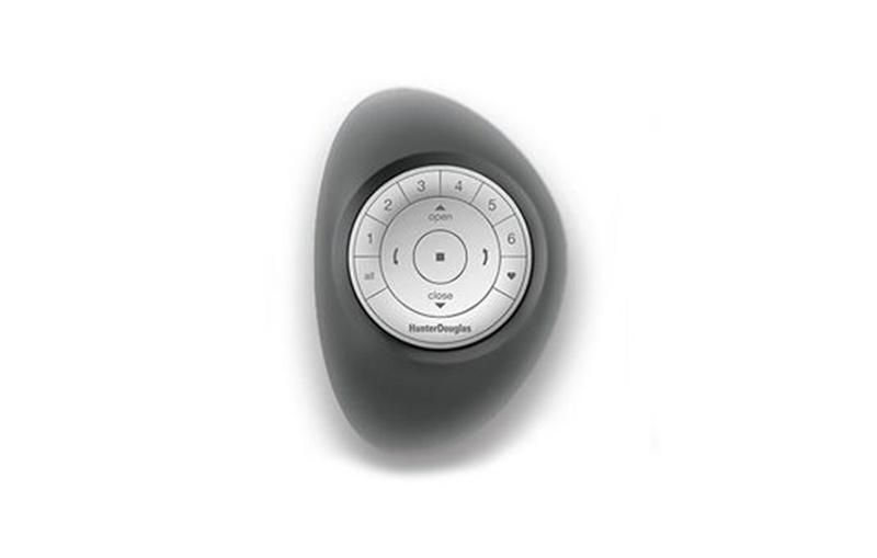 Hunter Douglas remote control device with a sleek black casing and circular white button interface, used for operating window treatments.