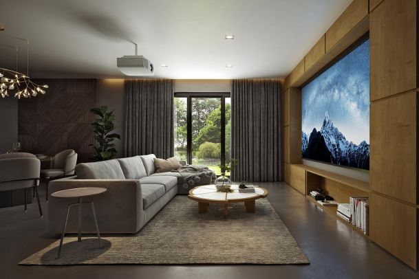 A contemporary living room with a large sectional sofa, a round coffee table, and a projector screen, with a view of a garden outside.